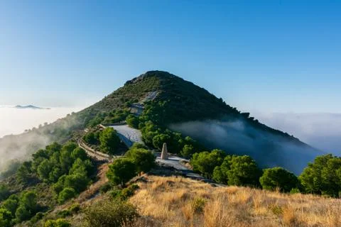 Mountain summit surrounded by a sea of clouds. Stock Photos