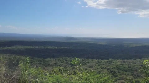 Mountain summit view over green plains and sea with radiant sun flare 4K Video stock 329074101