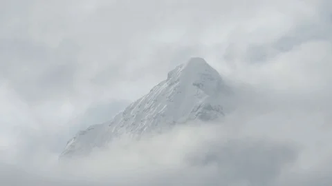 Mountain surrounded by shifting clouds Stock Footage 74981413