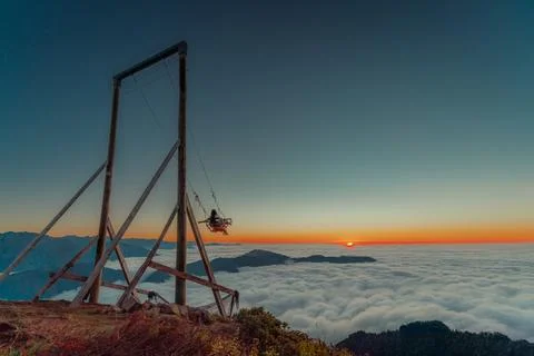 Mountain swing above a misty clouds mountain valley Fotos Stock