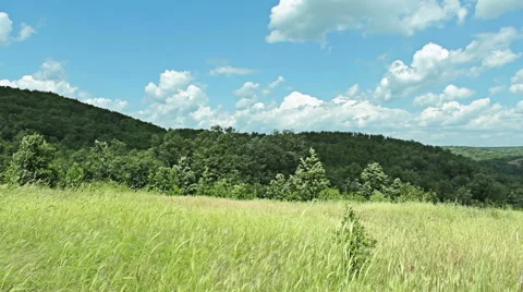 Mountain time lapse with moving clouds over the wheat green fields Stock Footage 46590713