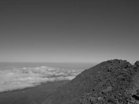A mountain top with a cloudy sky in the background Stock Photos