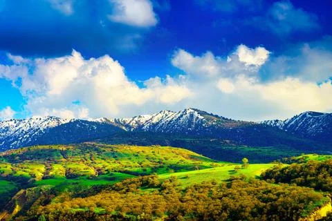 Mountain top covered with young snow and illuminated by the sun on a sunny .. Stock Photos