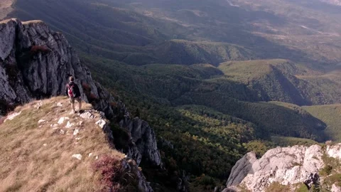 Mountain top figure looking outwards 库存影片 168839445