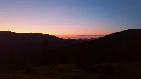 Mountain top horizon sunset with cold colors - Panning right with silouhette Stock Footage 119178901