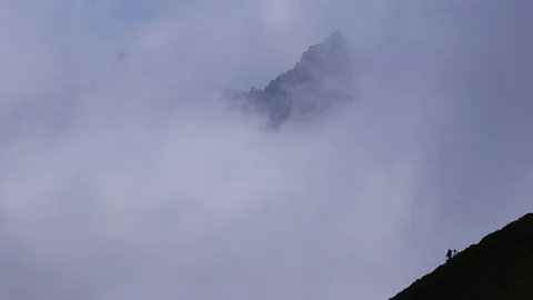 Mountain top through thick white clouds Stock Footage 100962317