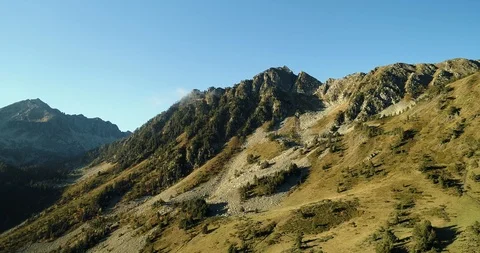 Mountain top with trees and jagged rocky outcrops drone aerial 4k Video stock 125758807