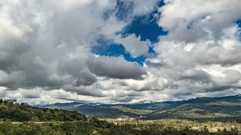 Mountain Town Time Lapse with Dramatic Cumulus Clouds and Green Mountains Stock Footage 278476692