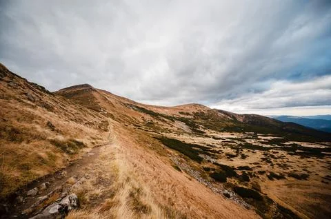 Mountain Trail Under Cloudy Sky Stock Photos