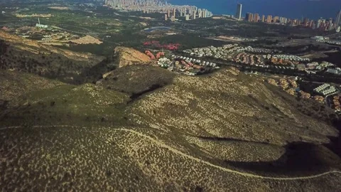 Mountain with trails on the background of the city on the coast Stock Footage 239656234