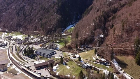 Mountain train exiting forest toward station Видео 332134484