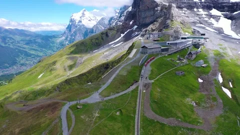 Mountain Train leaving the highest station on a tall Mountain Stock Footage 247794871