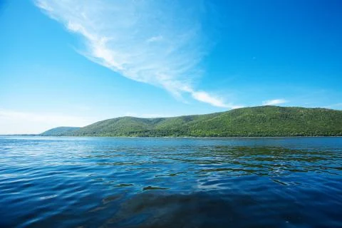 Mountain with trees against the blue sky and the river Foto stock