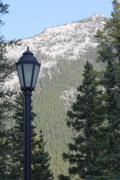 Mountain with trees and lamp post in foreground Stock Photos