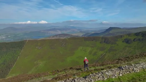 Mountain trekker stopped on path admiring distant misty mountains and Stock Footage 276739823
