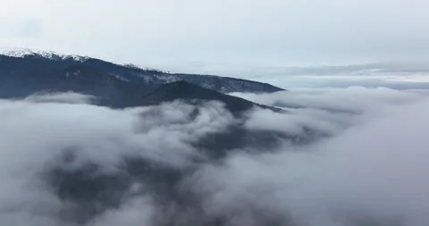 Mountain under a cloud of heavy fog. Drone flight over the clouds in the morning Stock Footage 174425477