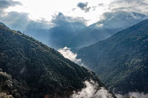 Mountain valley covered with dense cloud and bleeding sun rays at morning fro Fotos de archivo
