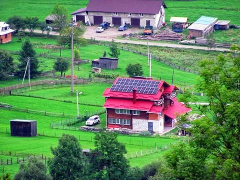 Mountain valley development featuring a modern house with solar panels on roof Stock Photos