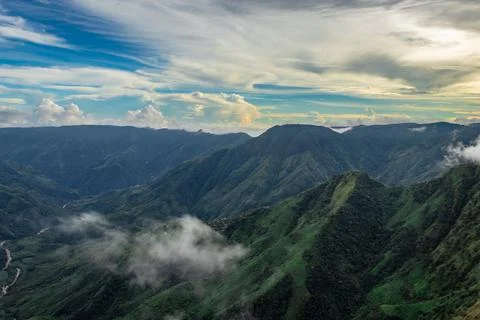 Mountain valley with dramatic sunset sky and low clouds at evening 스톡 사진