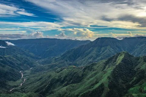 Mountain valley with dramatic sunset sky and low clouds at evening 库存照片