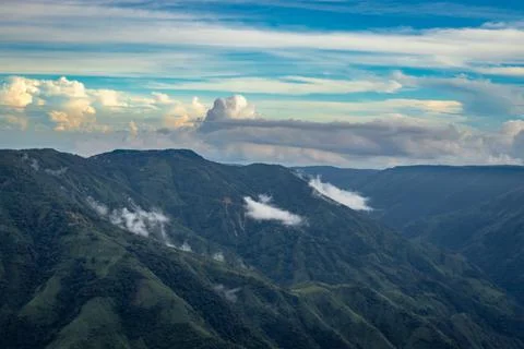Mountain valley with dramatic sunset sky and low clouds at evening Stock Photos