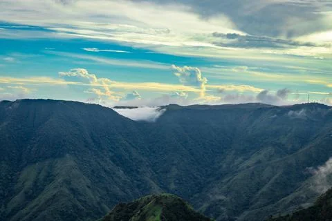 Mountain valley with dramatic sunset sky and low clouds at evening Foto stock