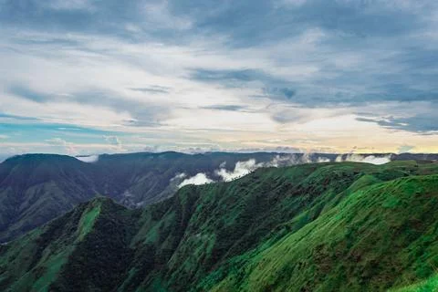 Mountain valley with dramatic sunset sky and low clouds at evening Stock-Fotos
