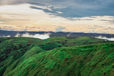 Mountain valley with dramatic sunset sky and low clouds at evening 스톡 사진