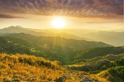 Mountain valley during sunset or sunrise. Rocks and slopes covered with gre.. 写真素材