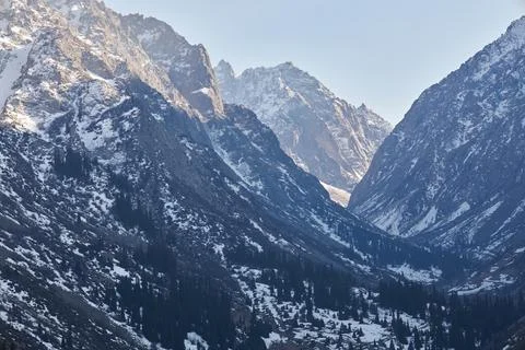 Mountain valley in early spring. Slightly snow-covered rocky Mountains slopes Stock Photos