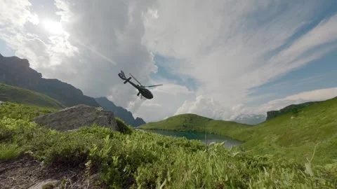 Mountain valley lake with taking off helicopter aerial follow view Stock Footage 330055642