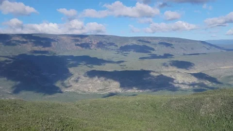 Mountain valley landscape framed by trees with blue sky and clouds 4k Vidéo 329074629
