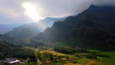 Mountain valley landscape with sunlight breaking through clouds Stock Footage 346323828