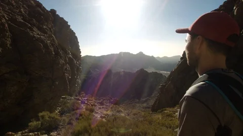 In a Mountain Valley. Man Looking Towards the Sun Stock Footage 77567523