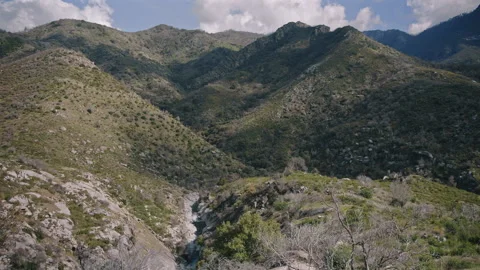 Mountain Valley with Small River Flowing through Hills Stock Footage 314894561