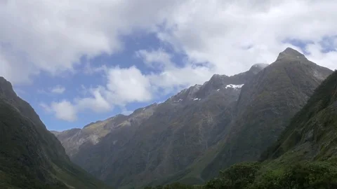 Mountain valley time lapse blue sky clouds passing by, Milford Sound fiordlands Stock Footage 84644345