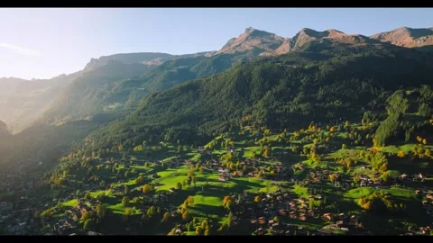 Mountain valley view at sunset with lush greenery and farms Stock Footage 320304337