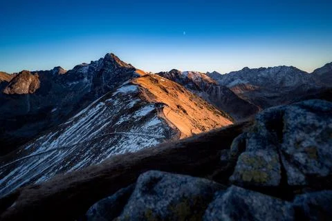 Mountain view during sunset just before nighttime. You can see the moon. Stock Photos
