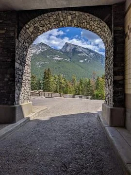 Mountain View Framed by Rustic Stone Archway Overlooking Pine Forest Stock Photos