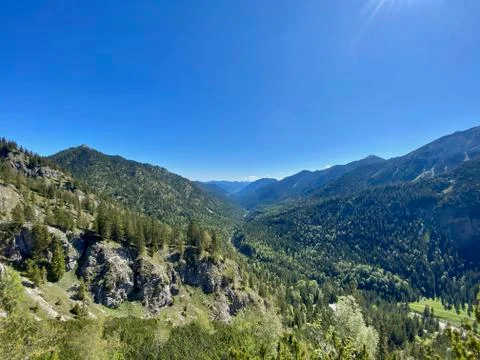 Mountain view over valley with forest, blue sky, alps, Bavaria, Germany Stock Photos