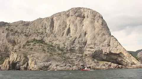 Mountain view from the sea with a boat floating in the waves Stock Footage 54566971
