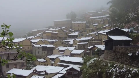 Mountain village covered with spring snow Stockbeeldmateriaal 340462482