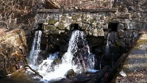 Mountain water flows from a stone dam Stock Footage 128235145