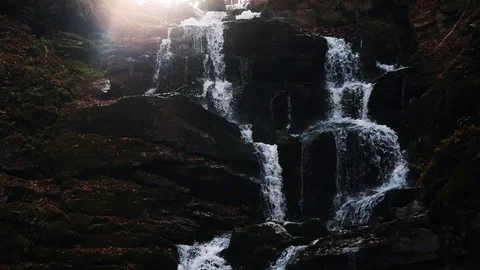 Mountain waterfall in autumn forest with lighting of sun. Stock Footage 128899201
