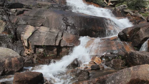 A mountain waterfall with clear water flows among large brown stones Stock-Footage 156169395