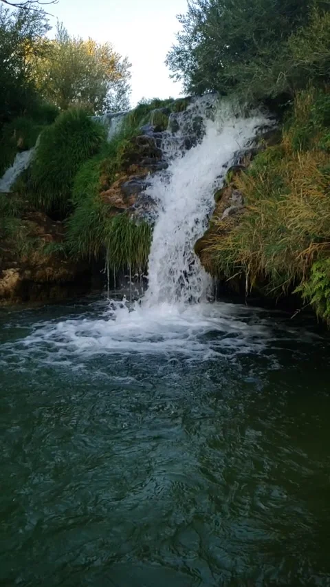 Mountain Waterfall Flowing into a Peaceful Valley Vídeos de archivo 337703181