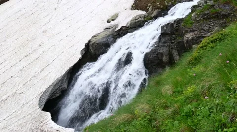 Mountain Waterfall flowing Under Ice. Melting of the glacier in Spring 스톡 동영상 65763969