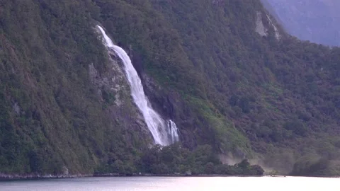 Mountain waterfall with many green trees in New Zealand Milford Sound Stock Footage 132062636