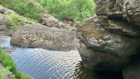 Mountain waterfall. Mountain river among gray huge boulders in the middle of a Stock-Footage 132904351