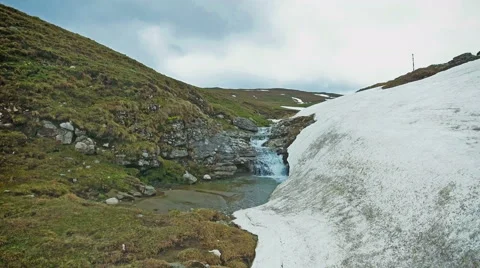 Mountain waterfall in spring with snow melting Stock Footage 63763535